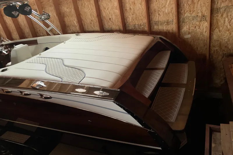 Slide: The Image of 2017 StanCraft 24 Highboy Surf boat with elegant white upholstery in a wooden garage. - 4