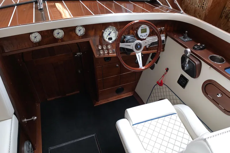Slide: The Image of 2017 StanCraft 24 Highboy Surf boat interior with wooden dashboard and steering wheel. - 8