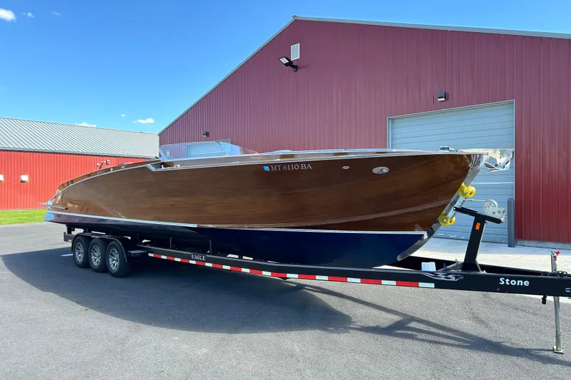 Slide: The Image of 2013 StanCraft 360 Rivelle boat on trailer, parked outside red building. - 11