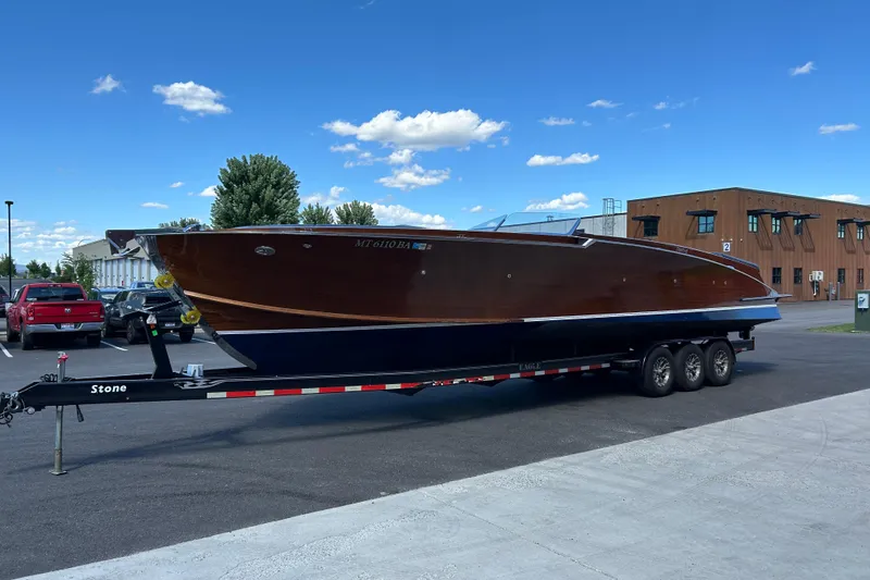 Slide: The Image of 2013 StanCraft 360 Rivelle boat on trailer, parked outdoors under blue sky. - 6