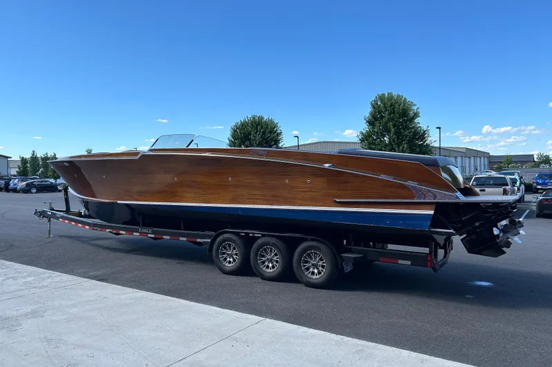 Slide: The Image of 2013 StanCraft 360 Rivelle boat on trailer, showcasing sleek wooden design under clear blue sky. - 8