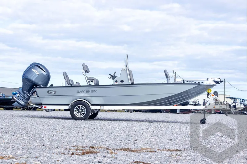 Slide: The Image of 2026 G3 Bay 19 GX boat with Yamaha motor on a trailer, parked on gravel. - 7