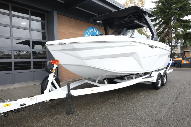 Slide: The Image of 2026 Tigé Z3 boat on trailer, parked outside a building. - 2