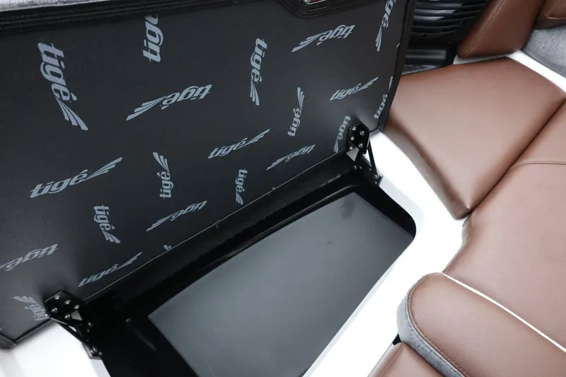Slide: The Image of 2026 Tigé Z3 boat interior with brown seating and branded storage compartment. - 21