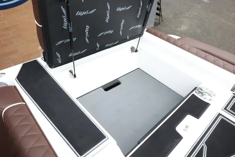 Slide: The Image of 2026 Tigé Z3 boat storage compartment with open lid and cushioned seating. - 47