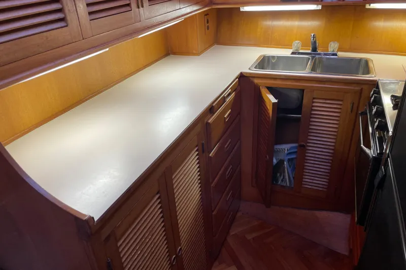 Slide: The Image of 1985 Nova 40 Sundeck Aft Cabin kitchen with wooden cabinets and dual sink. - 14