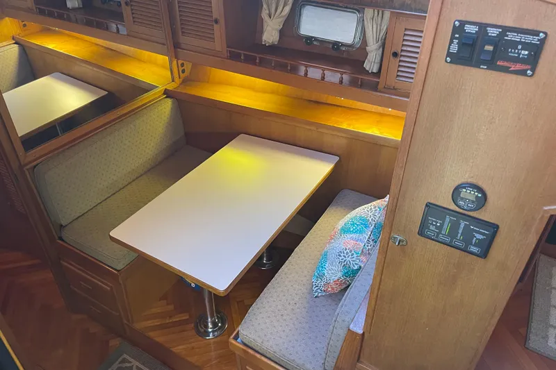Slide: The Image of 1985 Nova 40 Sundeck Aft Cabin interior with cozy dining area and wood accents. - 16