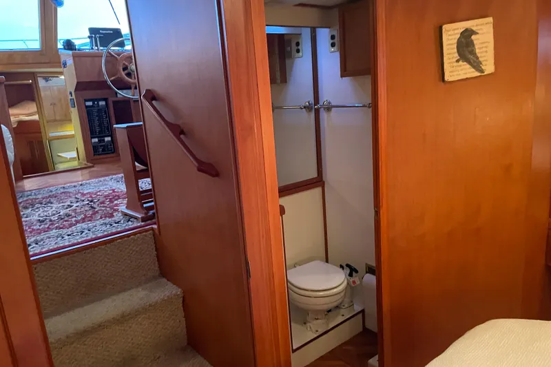 Slide: The Image of Interior of 1985 Nova 40 Sundeck Aft Cabin, featuring helm, stairs, and bathroom. - 24