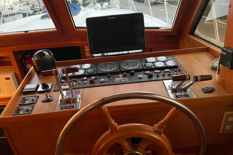Slide: The Image of Control panel of a 1985 Nova 40 Sundeck Aft Cabin boat with steering wheel. - 28