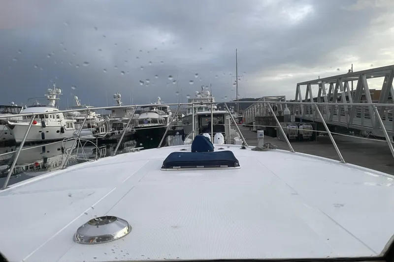Slide: The Image of 1985 Nova 40 Sundeck Aft Cabin yacht docked at marina under cloudy sky. - 29