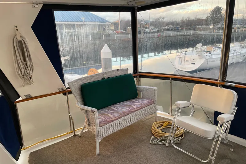 Slide: The Image of 1985 Nova 40 Sundeck Aft Cabin interior with seating, marina view, and nautical decor. - 6