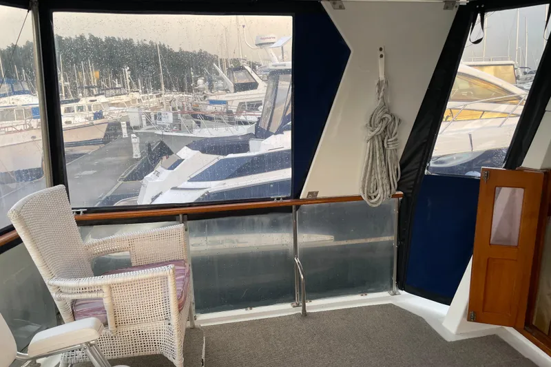 Slide: The Image of Aft cabin of 1985 Nova 40 Sundeck yacht with marina view and wicker chair. - 8