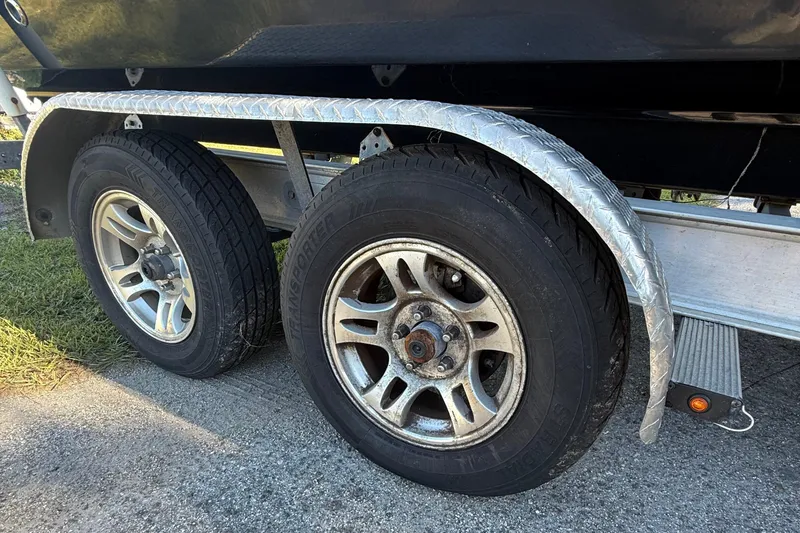 Slide: The Image of Trailer wheels of a 2021 Carolina Skiff 26 Ultra Elite boat on pavement. - 22