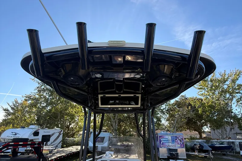 Slide: The Image of 2021 Carolina Skiff 26 Ultra Elite boat with T-top and rod holders, outdoor setting. - 42