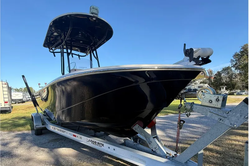 Slide: The Image of 2021 Carolina Skiff 26 Ultra Elite boat on trailer, parked outdoors under clear blue sky. - 9