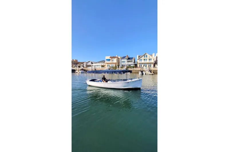 Slide: The Image of 1989 Duffy 20 boat cruising on a sunny day near waterfront homes. - 11