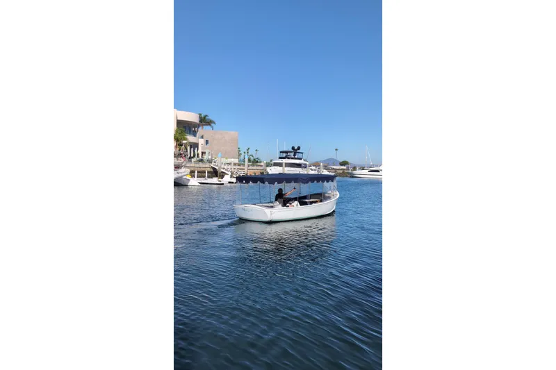Slide: The Image of 1989 Duffy 20 boat cruising in a sunny marina with clear blue skies. - 13