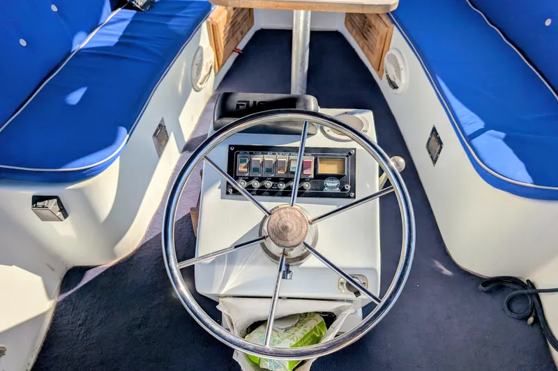 Slide: The Image of Interior of a 1989 Duffy 20 boat with steering wheel and blue seating. - 3