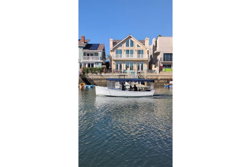 Slide: The Image of 1989 Duffy 20 boat cruising near waterfront homes under clear blue sky. - 5