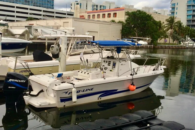 Slide: The Image of 2001 Pro-Line 25 Sport CC boat docked in marina, featuring Mercury Optimax engine. - 1