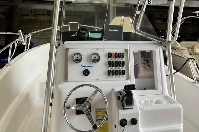 Slide: The Image of 2001 Pro-Line 25 Sport CC boat dashboard with steering wheel and control panel. - 10