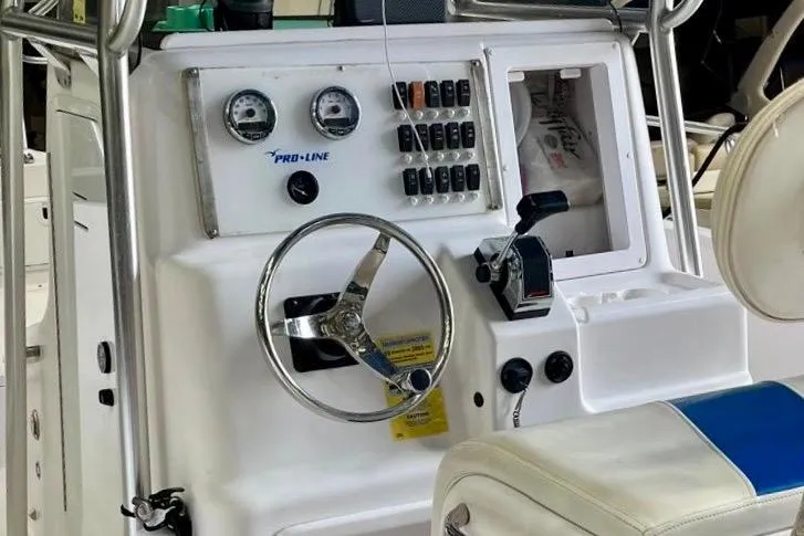 Slide: The Image of 2001 Pro-Line 25 Sport CC boat dashboard with steering wheel and control panel. - 11