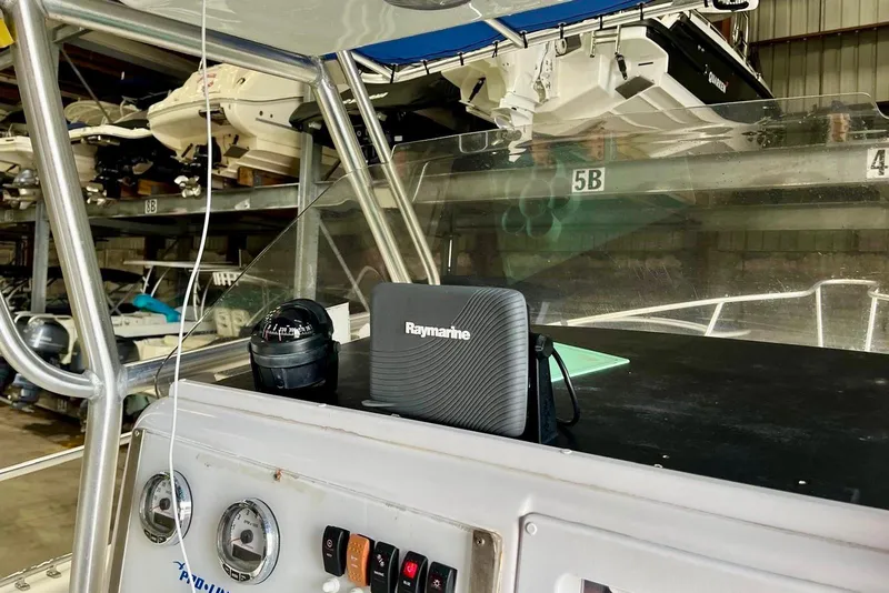 Slide: The Image of 2001 Pro-Line 25 Sport CC boat dashboard with Raymarine equipment in storage facility. - 12