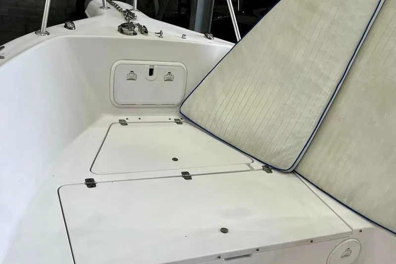 Slide: The Image of 2001 Pro-Line 25 Sport CC boat interior with storage compartments and cushioned seating. - 17