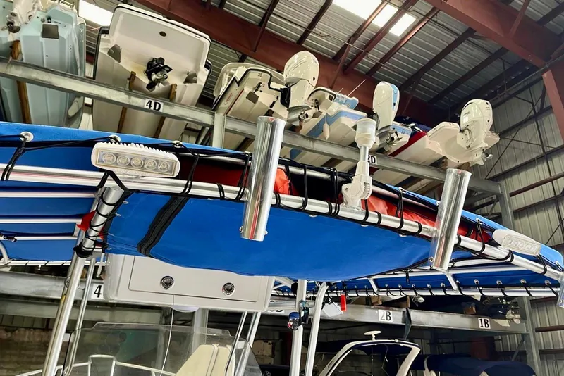 Slide: The Image of 2001 Pro-Line 25 Sport CC boat stored in a marina with blue canopy. - 24