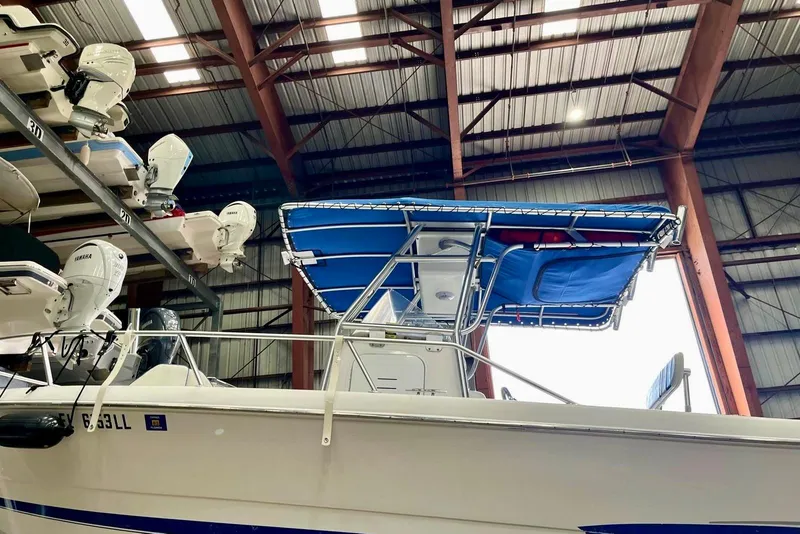 Slide: The Image of 2001 Pro-Line 25 Sport CC boat with blue canopy in storage facility. - 7