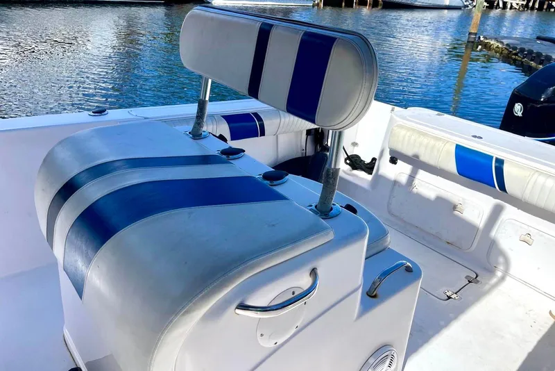 Slide: The Image of 2001 Pro-Line 25 Sport CC boat interior with blue and white seating by the water. - 8