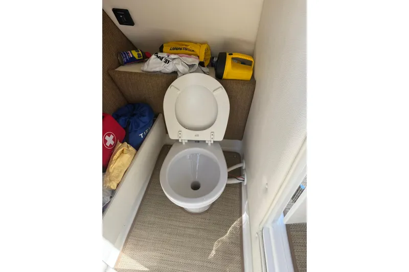 Slide: The Image of 2020 Cobalt 25SC boat interior with toilet and storage items. - 14