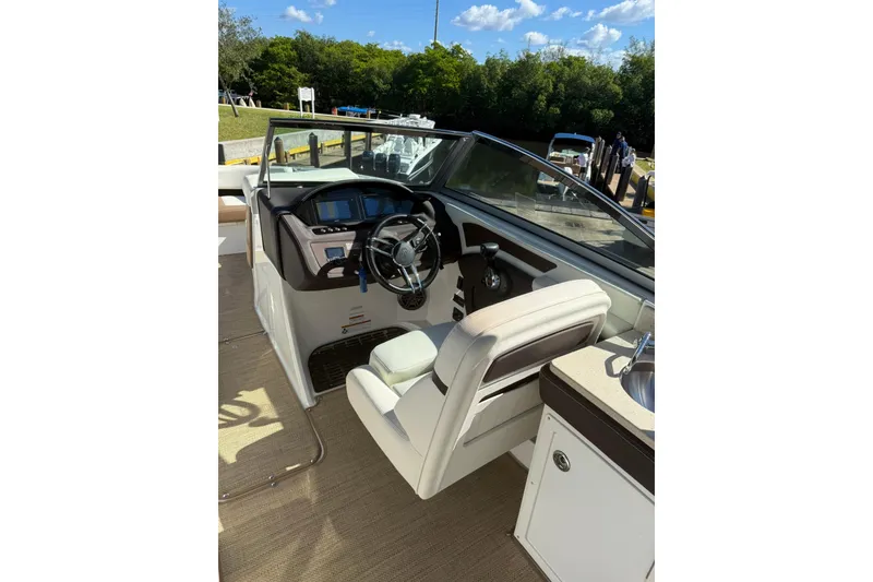 Slide: The Image of 2020 Cobalt 25SC boat interior with steering wheel and dashboard, docked under blue sky. - 16