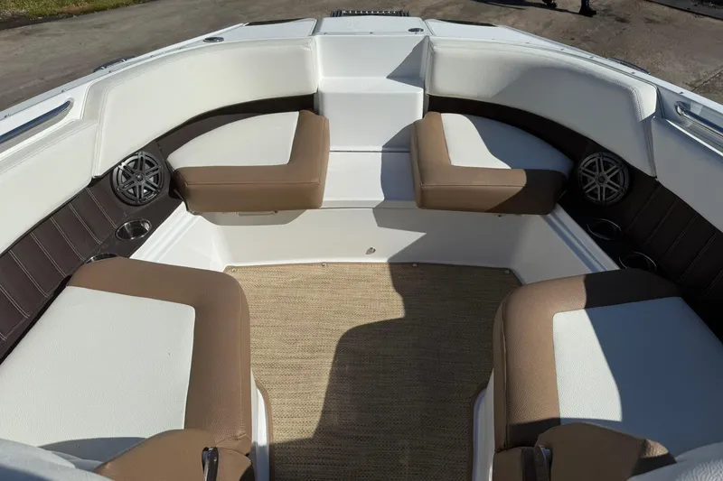 Slide: The Image of 2020 Cobalt 25SC boat interior with brown and white seating, speakers, and cup holders. - 8