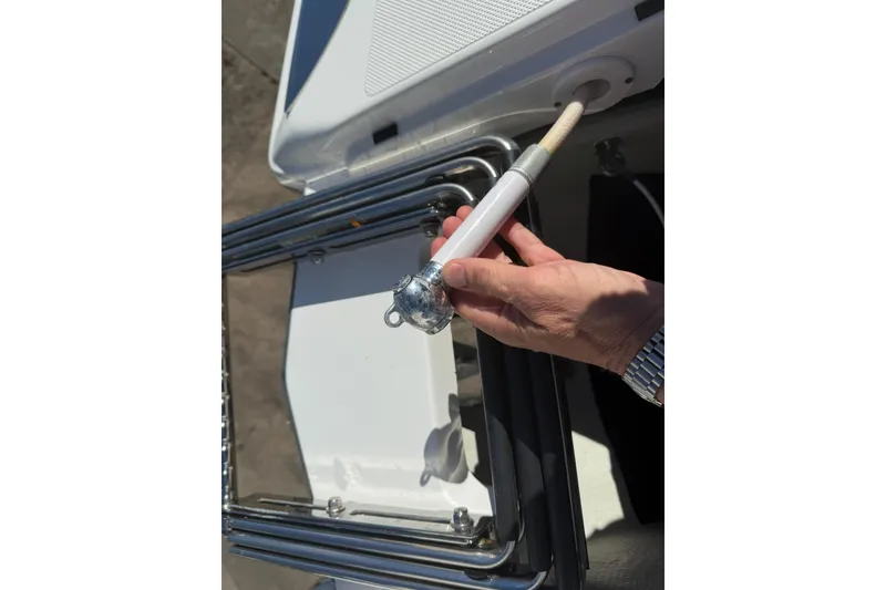 Slide: The Image of Hand holding a boat accessory on a 2020 Cobalt 25SC deck. - 9