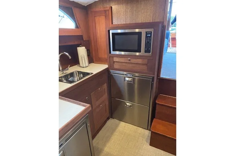 Slide: The Image of 1964 Pacemaker 36 Sportfisherman galley with microwave, sink, and wooden cabinetry. - 2