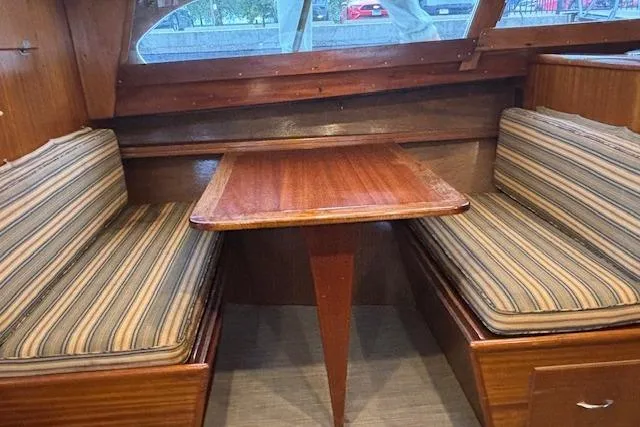 Slide: The Image of 1964 Pacemaker 36 Sportfisherman interior with wooden table and striped cushioned seating. - 20