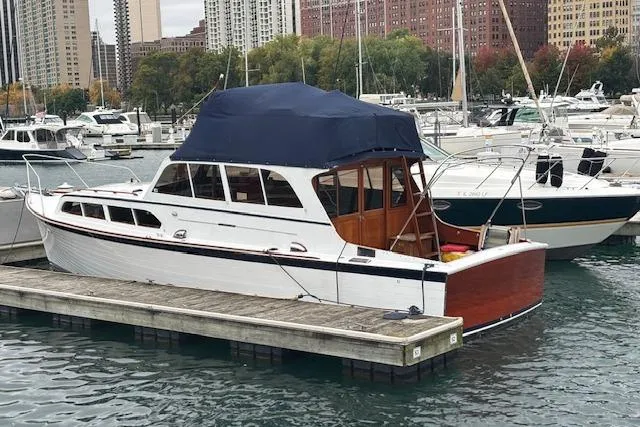 Slide: The Image of 1964 Pacemaker 36 Sportfisherman docked in a marina, featuring classic design and blue canopy. - 27