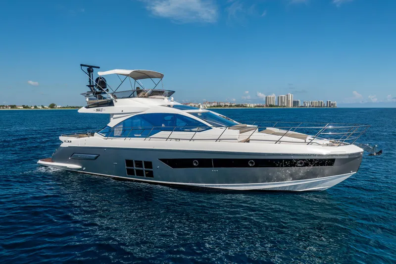 Slide: The Image of 2021 Azimut S6 Sportfly yacht cruising on blue ocean with city skyline in background. - 15