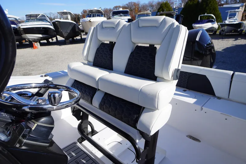 Slide: The Image of 2024 Tidewater 232 SS boat interior with dual white seats and steering wheel. - 13