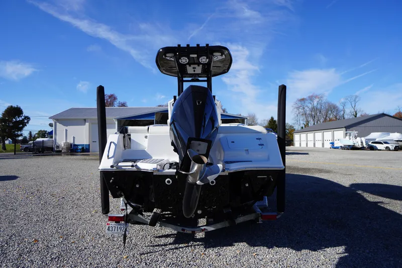 Slide: The Image of 2024 Tidewater 232 SS boat rear view, parked on gravel under clear blue sky. - 2