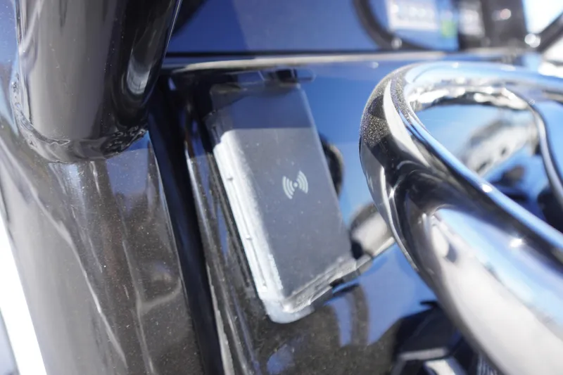 Slide: The Image of 2024 Tidewater 232 SS boat dashboard with wireless charging pad and sleek black finish. - 22