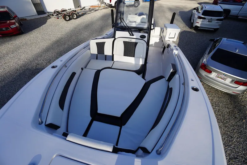 Slide: The Image of 2024 Tidewater 232 SS boat with spacious seating and sleek design in a gravel lot. - 27