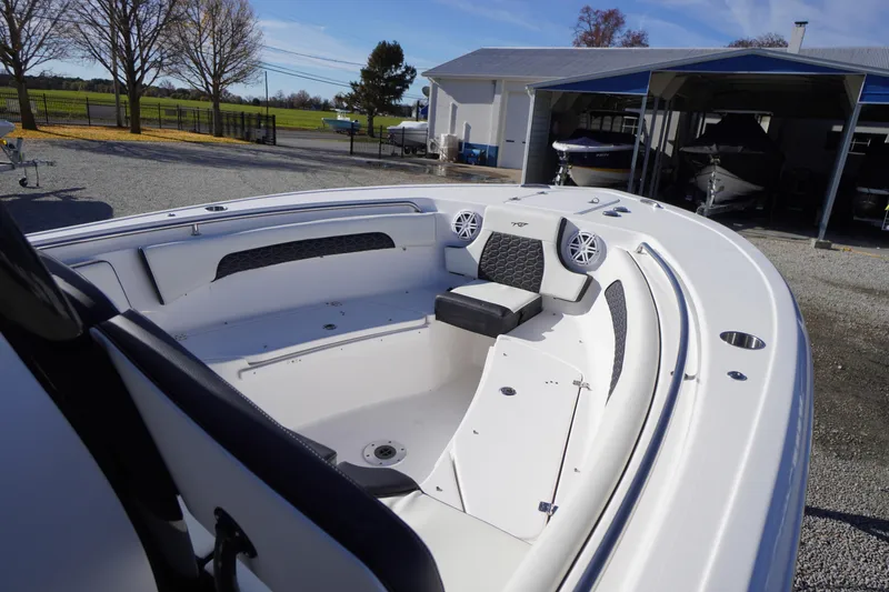 Slide: The Image of 2024 Tidewater 232 SS boat interior with seating and speakers, parked outdoors. - 40