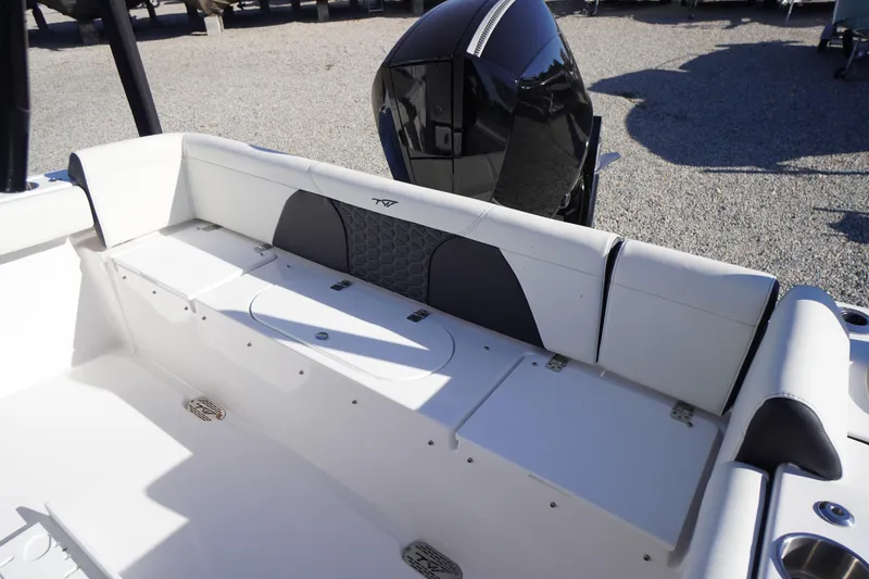 Slide: The Image of 2024 Tidewater 232 SS boat interior with cushioned seating and motor view. - 7