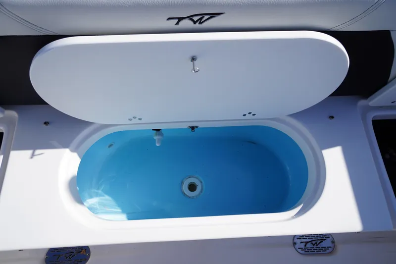 Slide: The Image of 2024 Tidewater 232 SS boat livewell with open lid, showcasing interior design. - 9