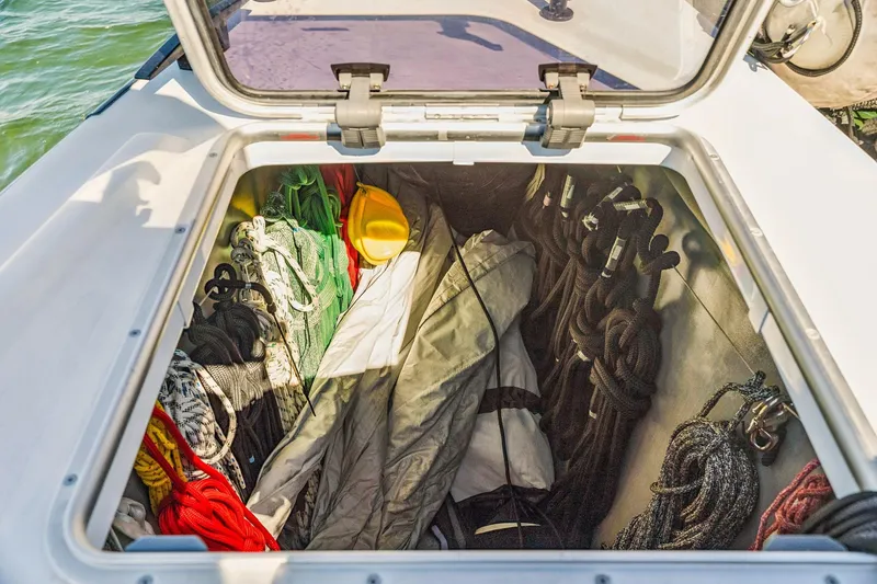 Slide: The Image of Open storage compartment on Balance 482 boat, containing ropes, tarp, and safety gear. - 105