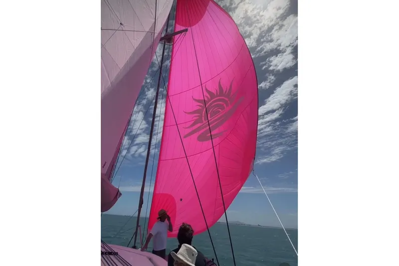 Slide: The Image of Sailboat with vibrant pink sail, Balance 482 model, 2023, under a partly cloudy sky. - 136