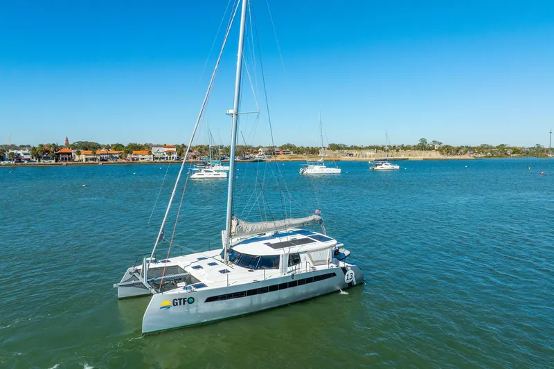 Slide: The Image of 2024 Balance 482 catamaran sailing in a calm bay with clear blue skies. - 137