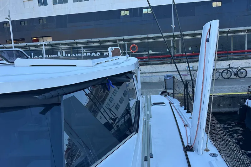 Slide: The Image of Catamaran Balance 482 sailing near coastal homes, 2024 model. - 6